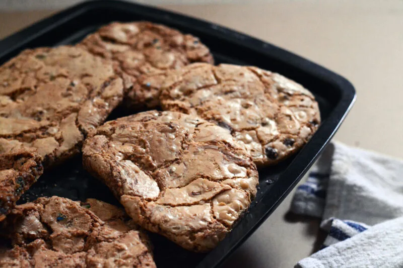 Multiple freshly baked DoubleTree chocolate chip cookie on a baking tray