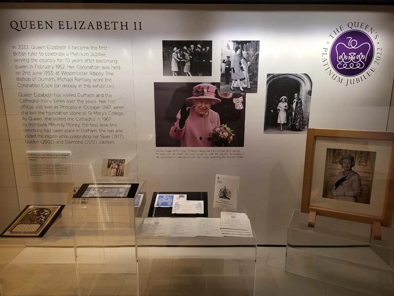 Display cabinet with image of Queen Elizabeth II in the centre of display and artefacts under the image. 