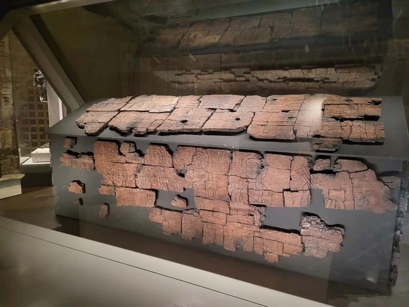 Close up image of St Cuthbert's wooden coffin. Pieces of original carved timber showing images of faces