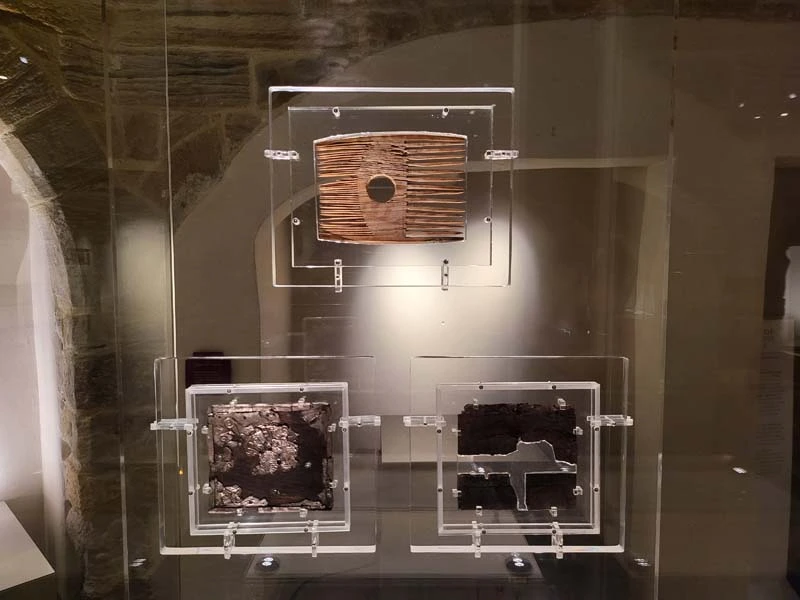 Ivory comb in display case with two pieces of portable altar displayed underneath