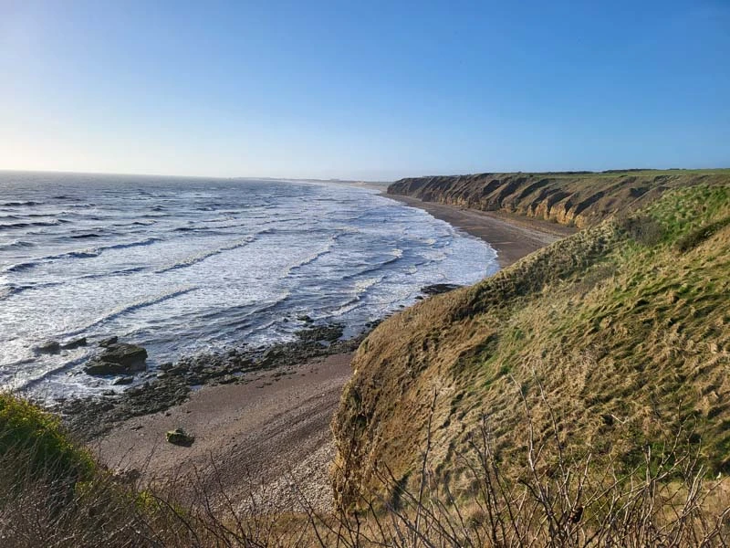 Rugged coastline. Sea waves washing up on a rocky shore. Just one of many things to do in Durham for couples