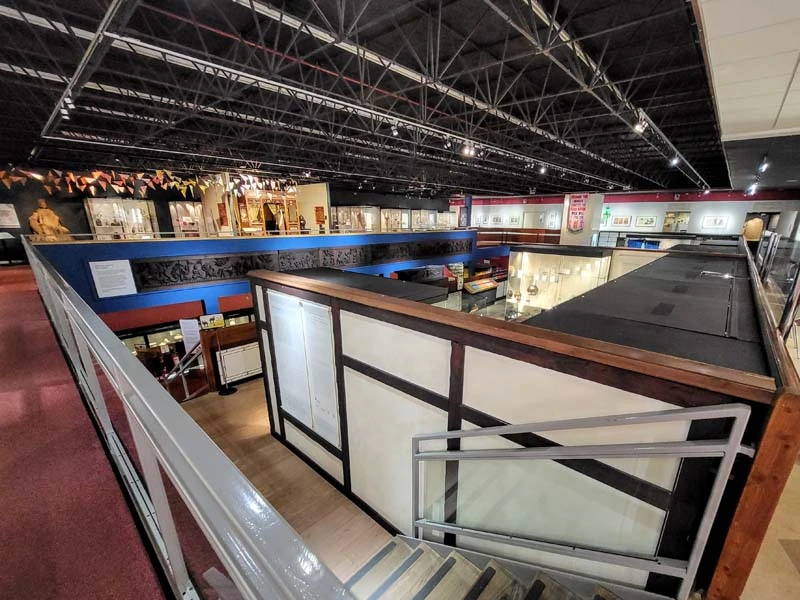 Interior of museum. Wide angle showing the museum layout. A staircase leading to lower museum levels can be seen in lower half of photo. Top half shows various exhibits in the museum space. Just one of many things to do in Durham for couples