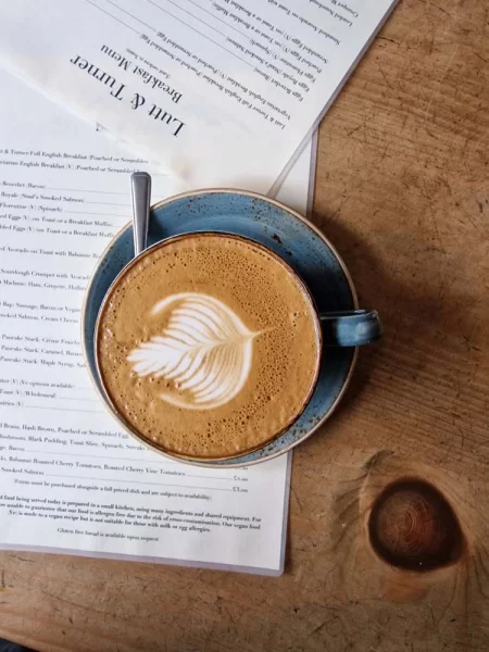 Coffee on wooden table surrounded by menus