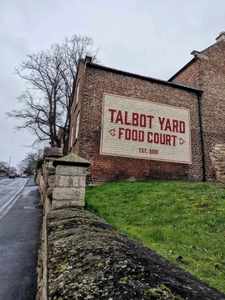 External sign of Talbot Yark Food Court on the side of one of the historic buildings located in the courtyard